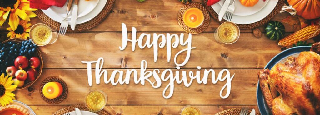 White colored Happy Thanksgiving text on a thanksgiving themed table