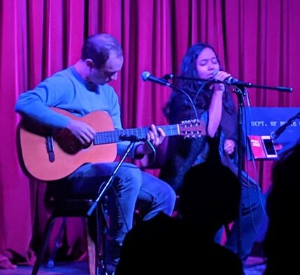 students demonstrate their musical abilities on stage during open mic night