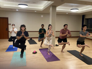 UT students holding a yoga pose.