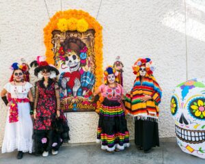 Women dressed in traditional clothing celebrating Dia de los Muertos. 