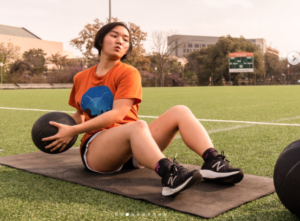Woman exercising with medicine ball outdoors. 