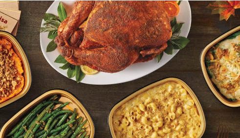 A thanksgiving meal with Turkey as the focused is layed on a table