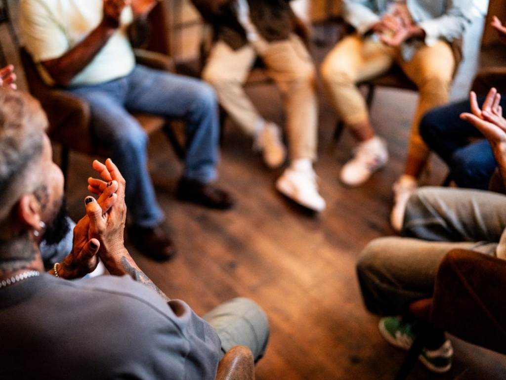 UT Counseling and Mental Health Center (CHMC) text is on top of a transparent UT orange background which is overlaid an image of students in a circle