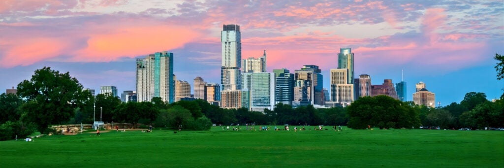View of the Austin skyline during a beautiful sunset from the bright green fields of Zilker Park