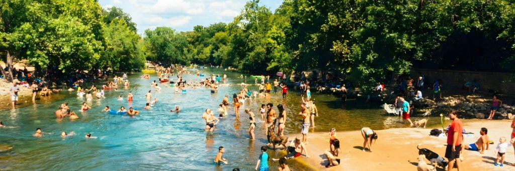 Swimmers enjoy the beautiful and cool waters of Barton Springs on a hot day