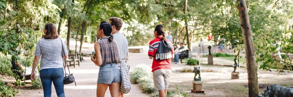 Visitors walk the grounds of the Umlauf Sculpture Garden