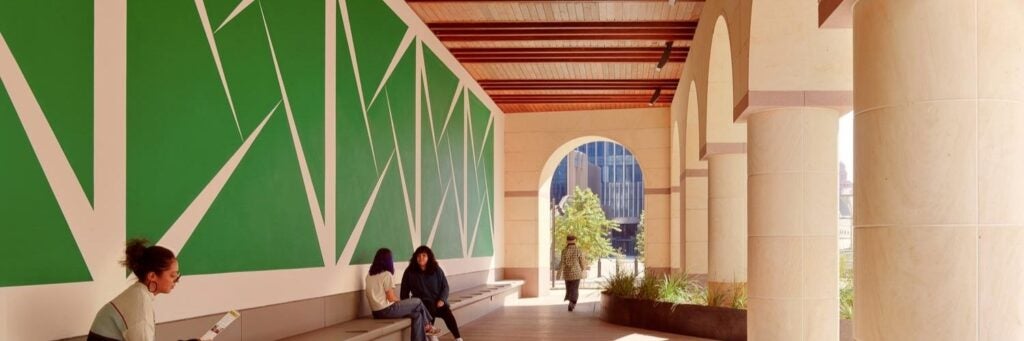 An outdoor installation translated as "Green How I Want You Green" from the Blanton is displayed on a UT campus building