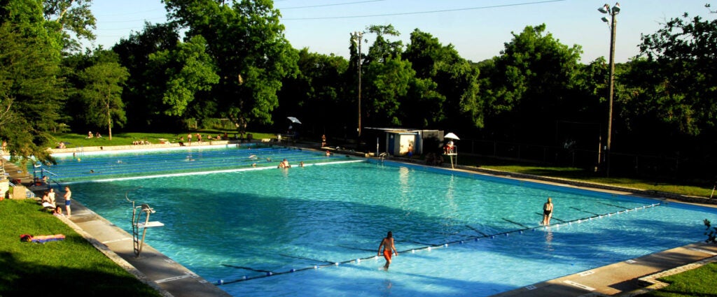The cool spring water of Deep Eddy pool looks crisp and light blue while inviting swimmers on a sunny summer day
