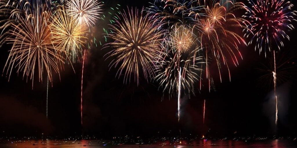 A colorful fireworks display over a body of water at night.