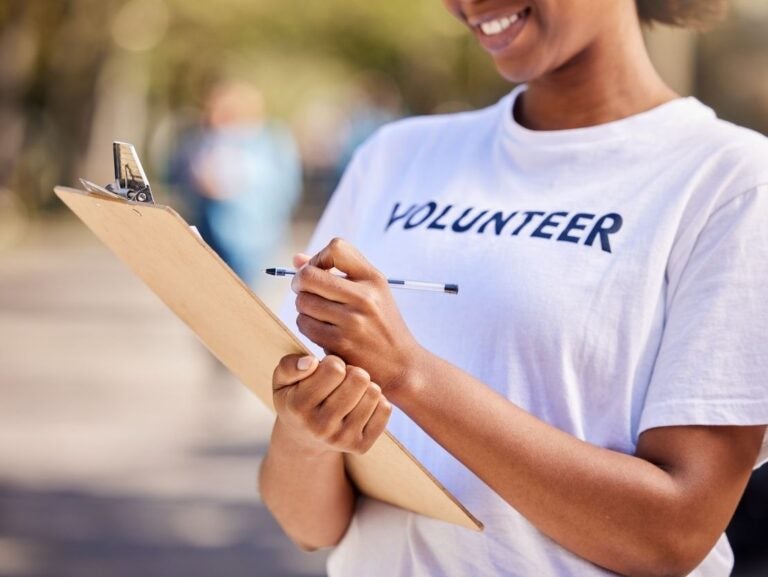 Young women with a volunteer t-shirt holding a clipboard