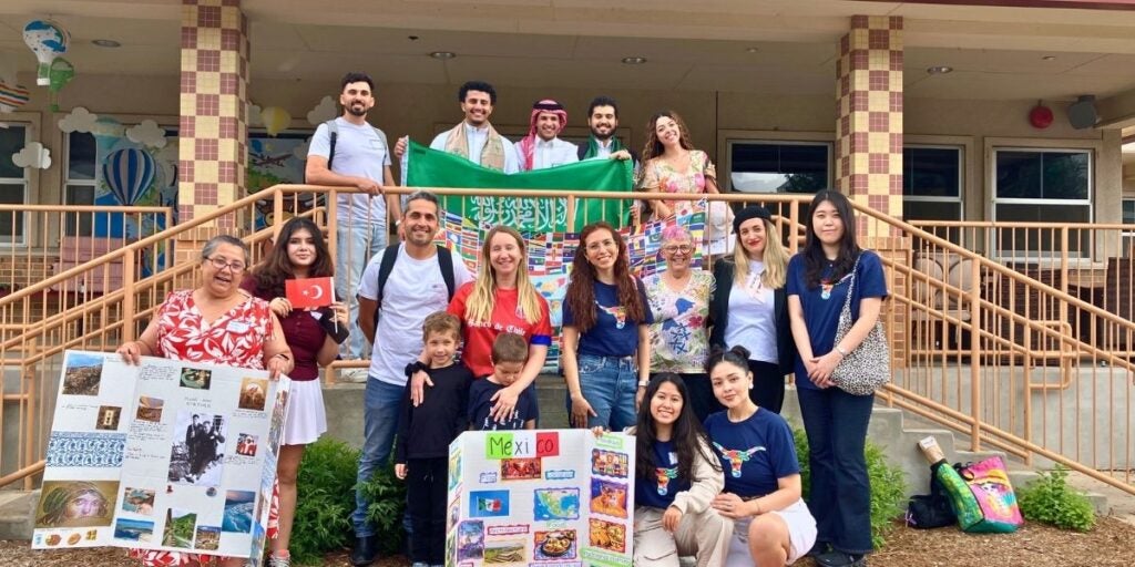 Group photo of people posing with cultural displays and flags.